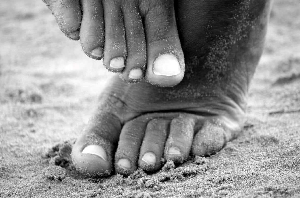 Feet resting gently in sand